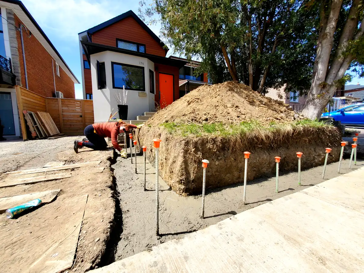 A retaining wall project mid-build, forms and rebar set for a fresh concrete pour